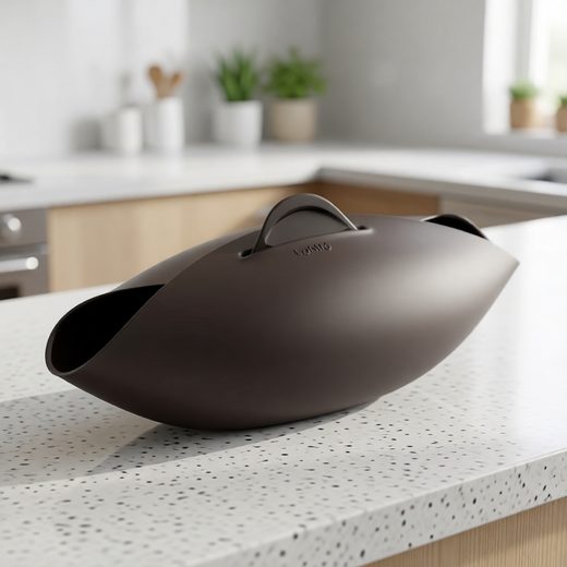 Sleek dark brown one-bowl bread maker appliance sitting on a white kitchen countertop.
