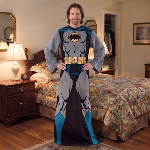 Man modeling a grey and black Batman wearable blanket featuring a bat symbol and sleeves.