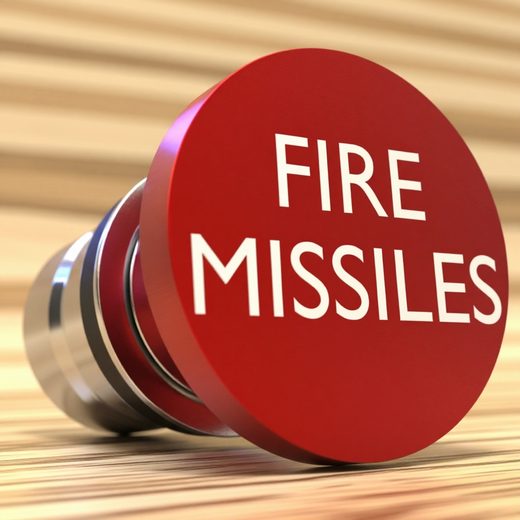 Close-up of a red circular button labeled Fire Missiles, designed as a car lighter device.