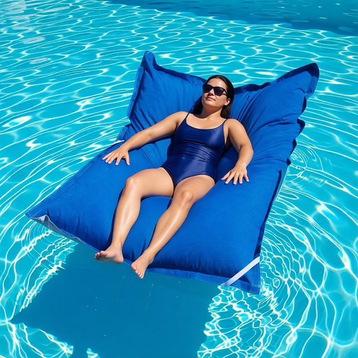 Oversized blue pool float beanbag chair resting in clear swimming pool water.
