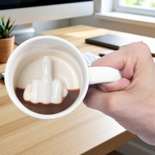 White mug with coffee revealing a hidden 3D middle finger gesture at the bottom.