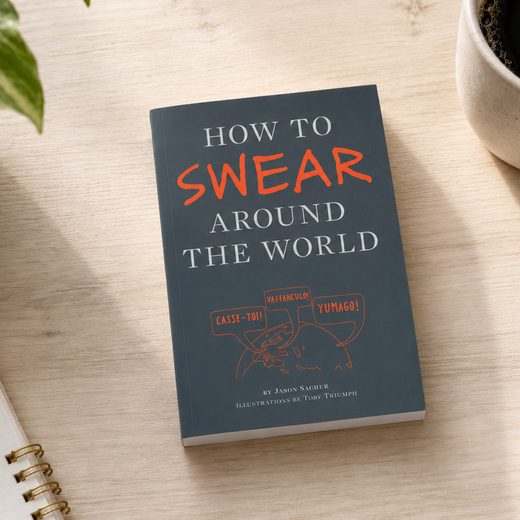 Hardcover book showing how to swear around the world with humorous illustrations.