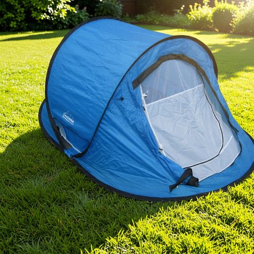Blue dome tent with mesh panels set up on a sunny green lawn.