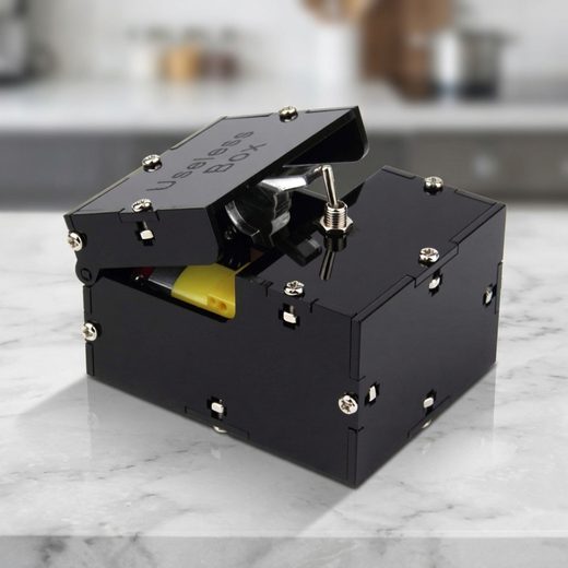 Small black switch box featuring a tiny mechanical finger popping out from the top.