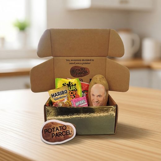 Custom message potato inside a brown box alongside colorful assorted candies and a tag.