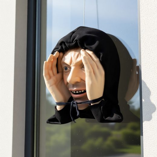 Creepy pale peeping tom figure wearing a black hood, positioned against a window.